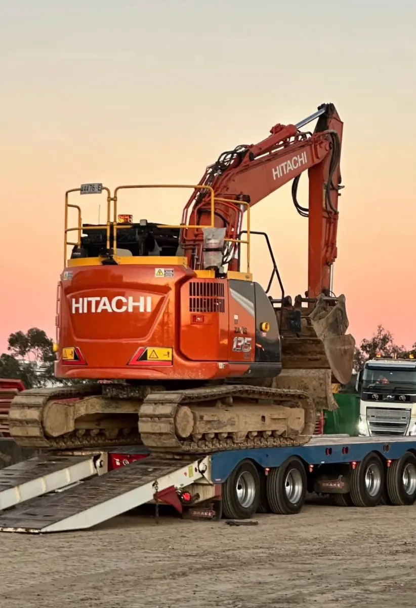 Mustang's 14 tonne Hitachi excavator loaded on a float at sunset